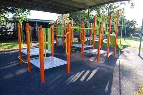 back view of the green and orange undercover play unit with rubber softfall